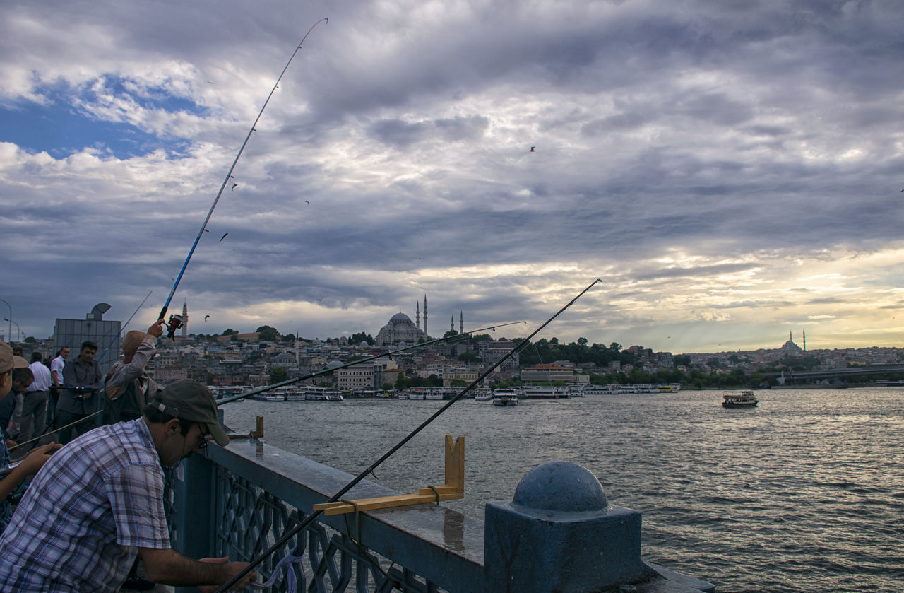 MAN FISHING AT RIVER AGAINST SKY