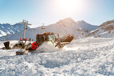 Traditional windmill on snow covered mountain against sky