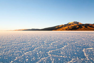 Scenic view of snowcapped mountains against clear blue sky