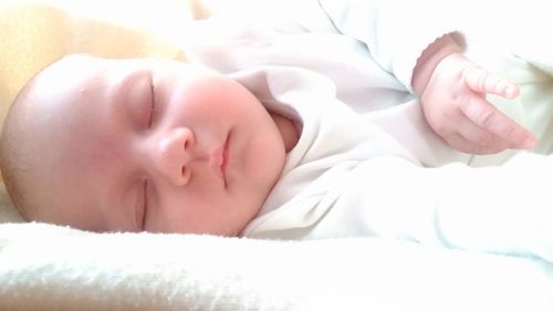 Close-up of baby sleeping on bed