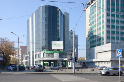 View of city street and modern buildings against sky