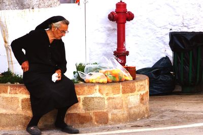 Side view of man standing against wall