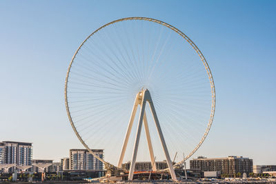 Ferris wheel against buildings in city