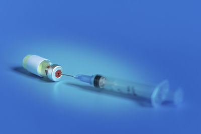 Close-up of eyeglasses on table against blue background