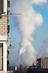 Low angle view of smoke emitting from chimney against sky