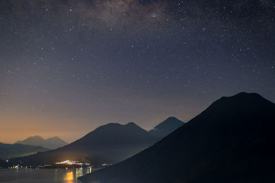 Scenic view of silhouette mountains against star field