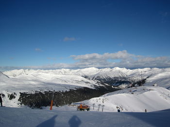 Scenic view of snowcapped mountains against blue sky