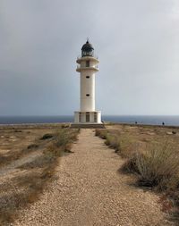 Lighthouse by sea against sky