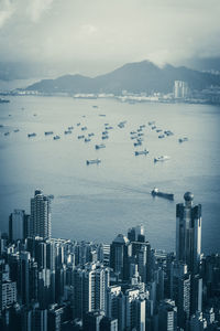 High angle view of city by sea against sky