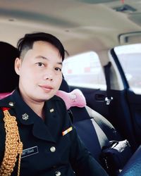 Portrait of woman wearing uniform while sitting in car