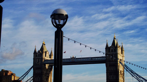 Tower bridge in city against cloudy sky