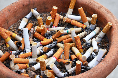 Close-up of cigarette butts in container