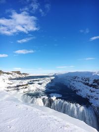 Scenic view of frozen sea against blue sky