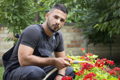 Young man sitting on flower pot