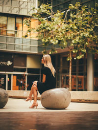 Woman sitting on seat in shopping mall