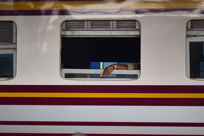 Cropped hand of man seen through train window