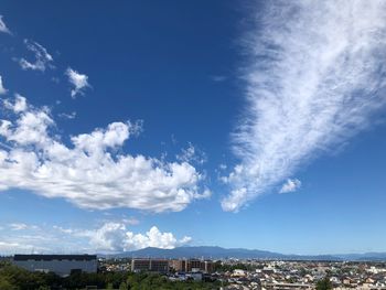 Aerial view of townscape against blue sky