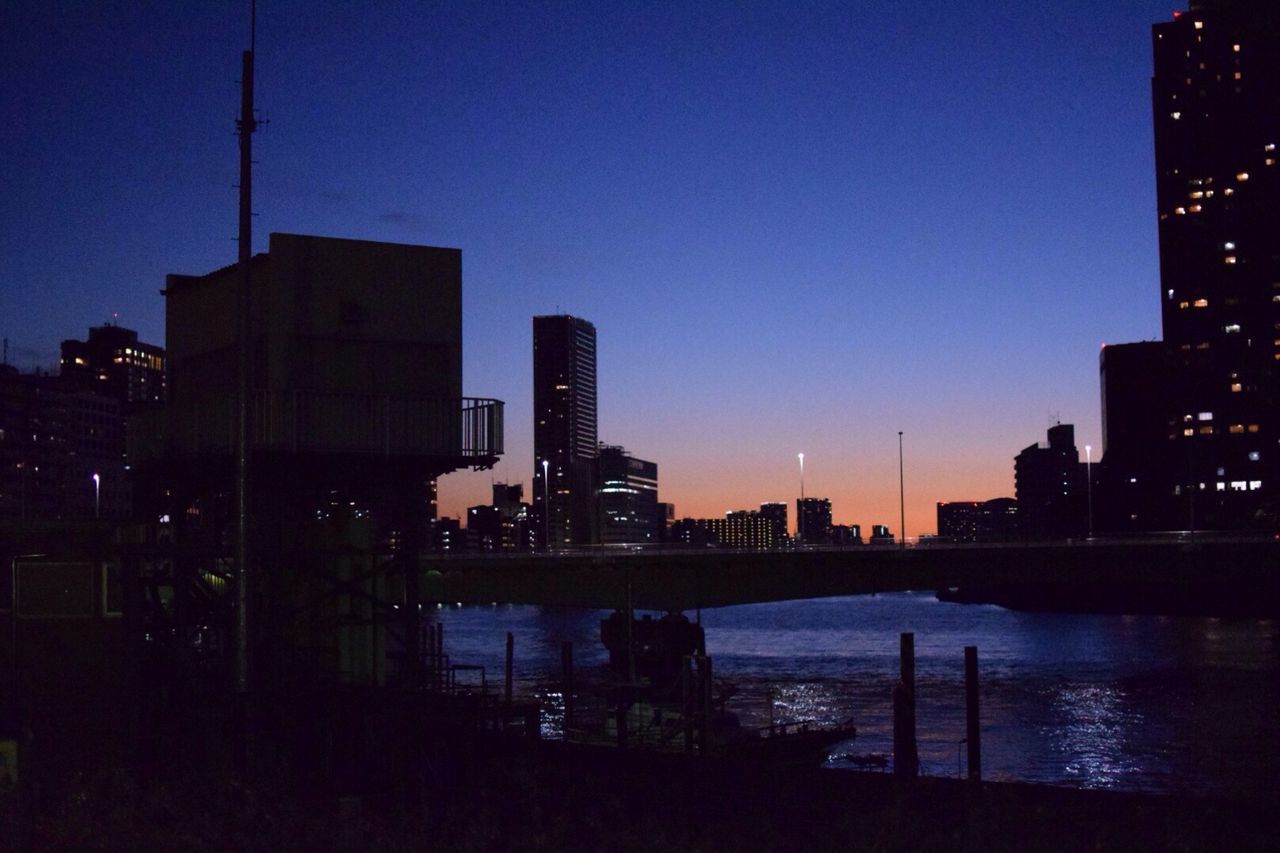 building exterior, architecture, built structure, city, illuminated, clear sky, silhouette, cityscape, blue, skyscraper, sunset, urban skyline, water, copy space, dusk, tower, skyline, sky, building, tall - high