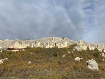 Low angle view of rocks on mountain against sky