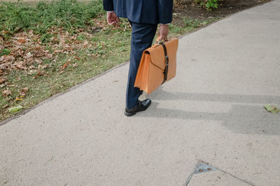 Low section of man walking on road