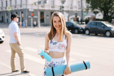 Portrait of smiling young woman on street in city