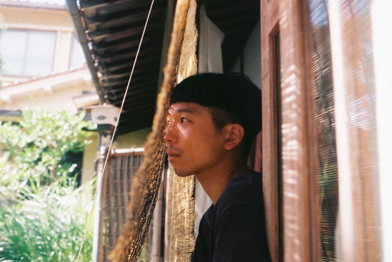 PORTRAIT OF A YOUNG MAN LOOKING AWAY OUTDOORS