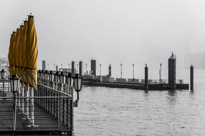 River and harbor against sky during foggy weather