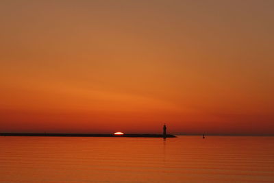 Scenic view of sea against orange sky