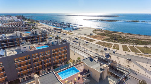 High angle view of buildings by sea against sky