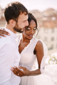 Happy couple embracing against townscape