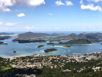 Aerial view of city by sea against sky