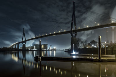 Illuminated cable-stayed bridge over river at night