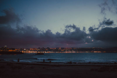 Sea by city against sky during sunset