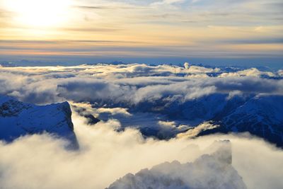 Aerial view of snowcapped mountains against sky during sunset