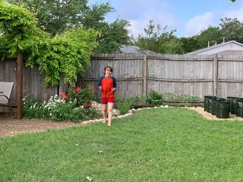 Boy standing by plants in backyard