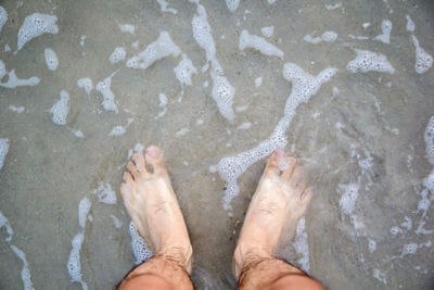 Low section of person standing on beach