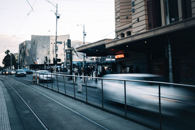 Cars on street in city against sky