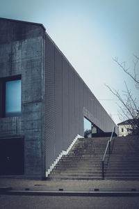 Low angle view of staircase by building against clear sky