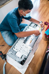 Technician assembling air conditioner on the floor.