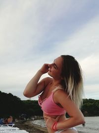 Beautiful woman on beach against sky