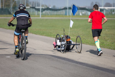 Rear view of people riding bicycle