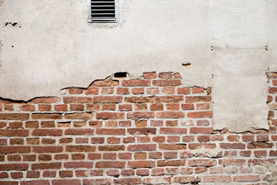 Low angle view of window on brick wall
