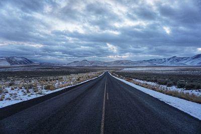 An empty road vanishes into the distance of the steens mountain range in central oregon.