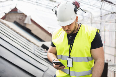 Manual worker using phone while working at construction site