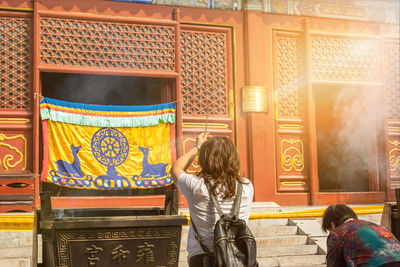 Rear view of people outside temple in building