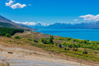 Scenic view of landscape and mountains against blue sky