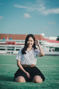 Portrait of a smiling young woman sitting outdoors