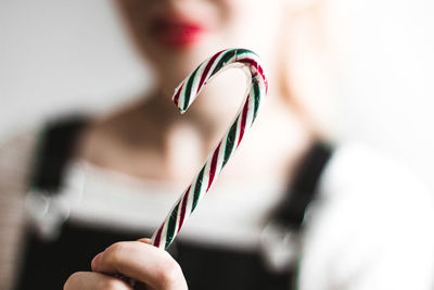 Midsection of woman holding candy cane