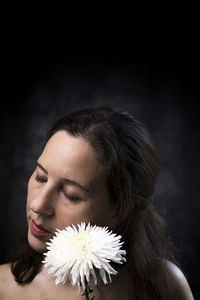 Woman in melancholic attitude with white chrysanthemum iv