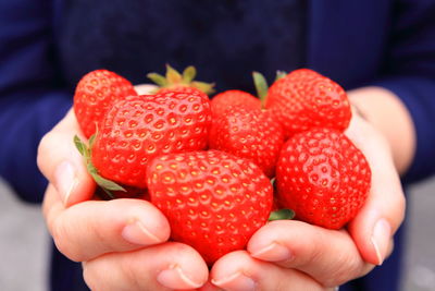 Close-up of hand holding strawberries